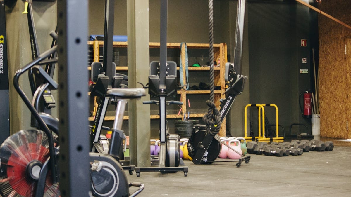 An indoor gym with various exercise equipment and weights ready for workout.